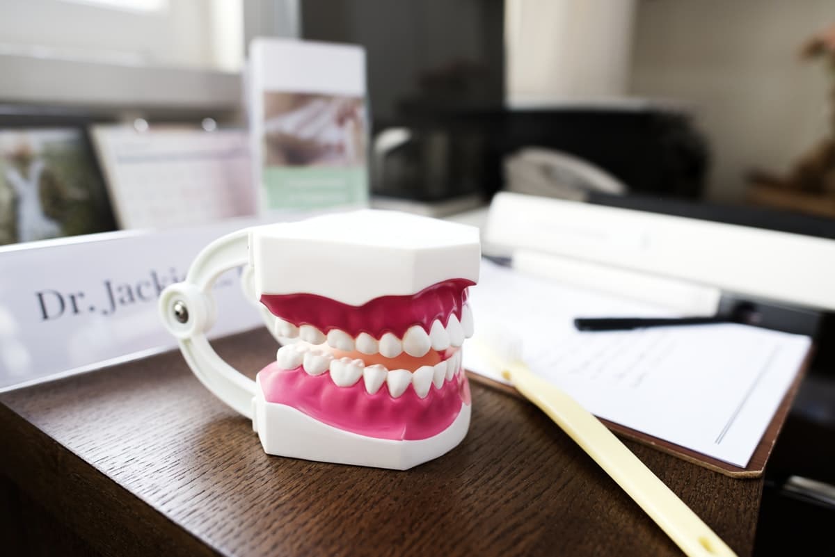 dentures sitting on dentist desk next to paperwork